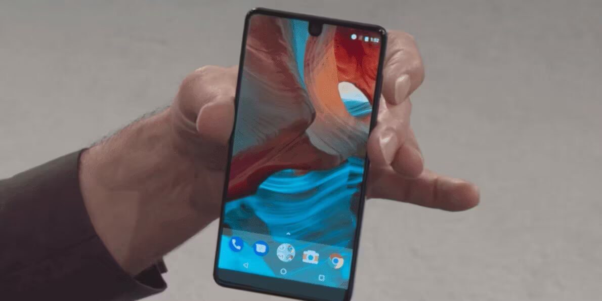 Мужчина держит смартфон Essential Phone с ярким экраном