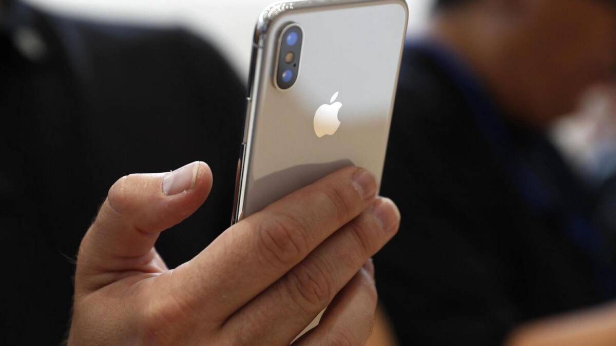 Рука держит iPhone X с металлическим корпусом