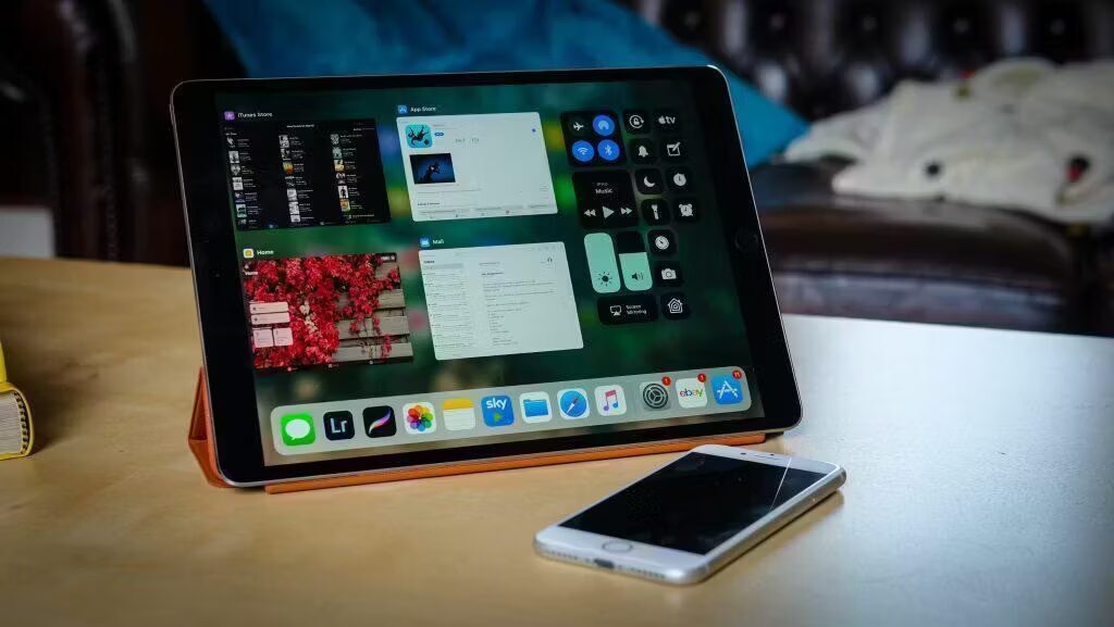 iPad с интерфейсом iOS 11 на деревянной поверхности