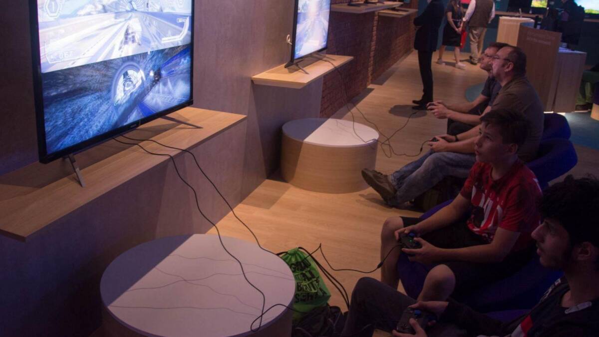 Экран телевизора с игрой на дисплее и игроки в игровой зал