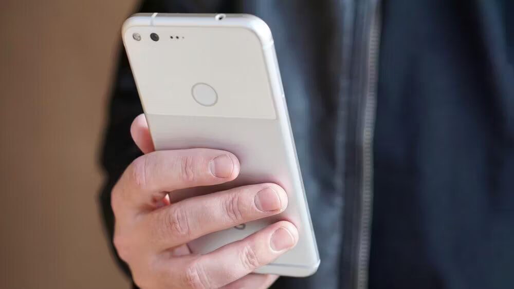 Человек держит белый смартфон HTC в руке крупный план