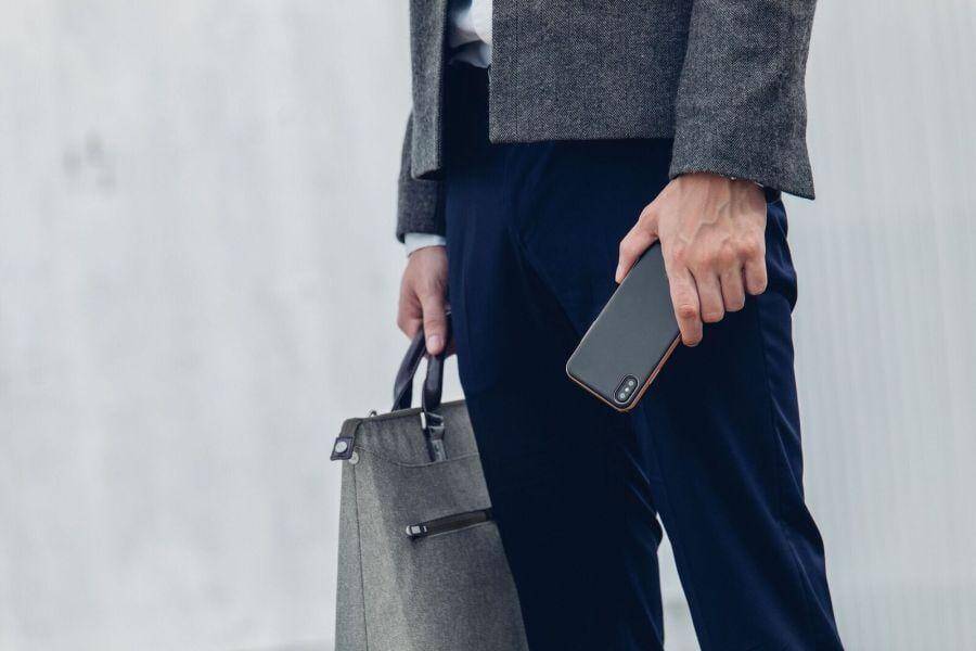 Moshi выпустила чехлы для iPhone 8 и iPhone X 9 Бизнесмен с телефоном iPhone X в руке и портфелем
