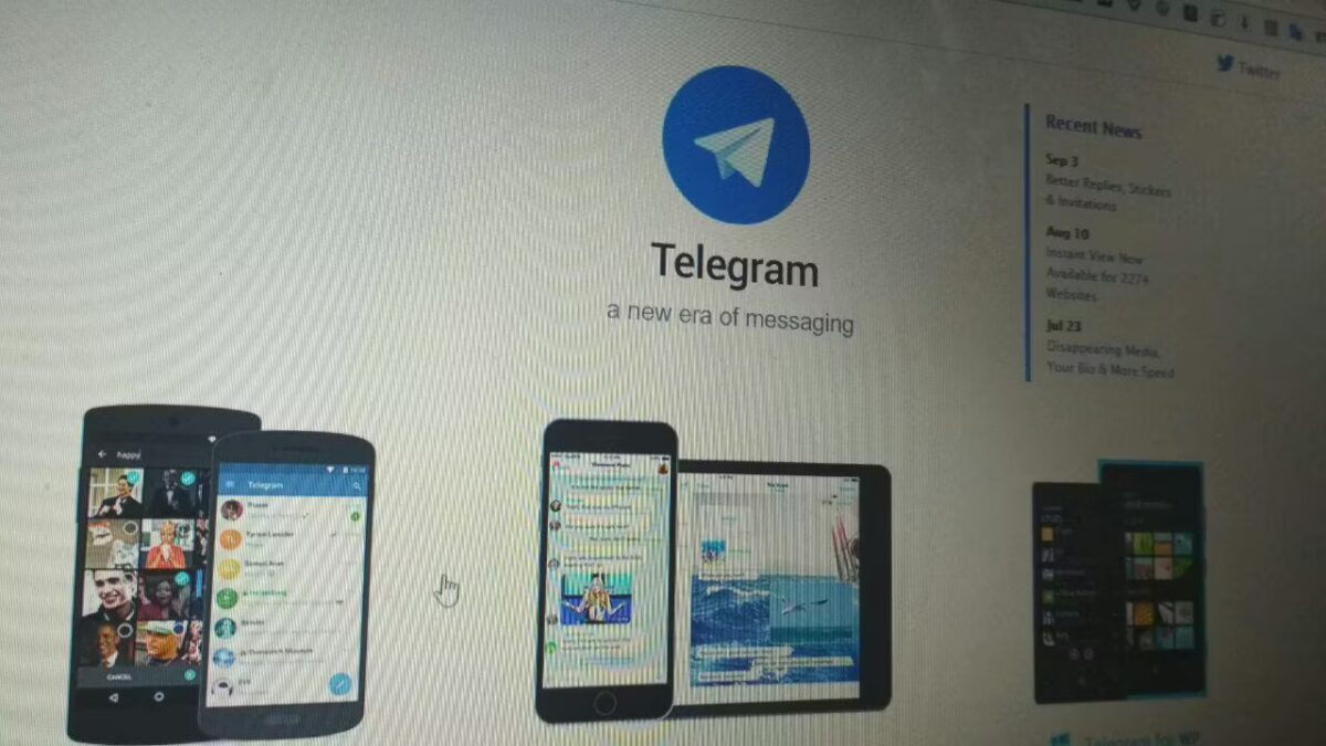 Экран компьютера с изображением логотипа Telegram и мобильных устройств