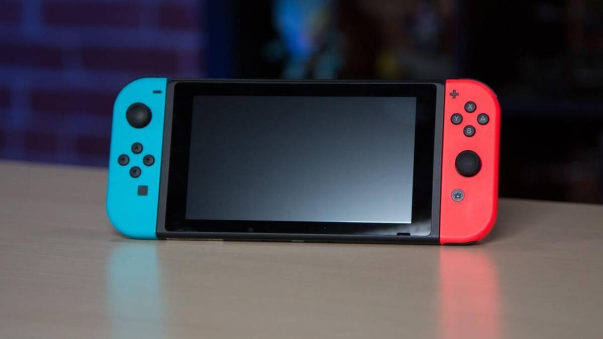 Nintendo Switch с ярко-синими и красными джойстиками на столе