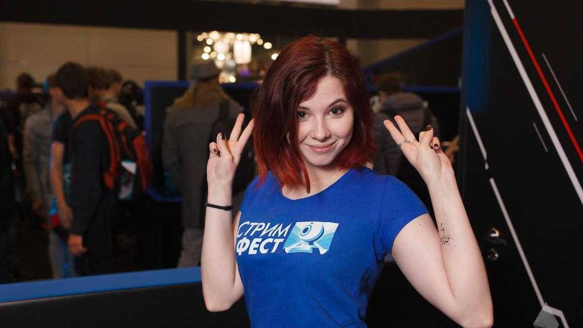 18+ Самые красивые девушки ИгроМир 2017 и Comic Con 63 Девушка в синей футболке с логотипом и руками в жесте мира