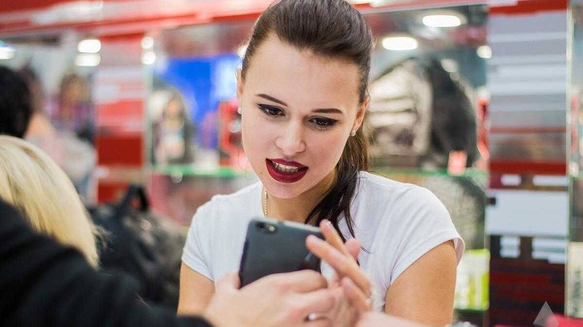 18+ Самые красивые девушки ИгроМир 2017 и Comic Con 90 Женщина с тёмными волосами и яркой помадой держит iPhone