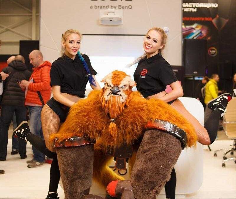 Две женщины в костюмах на выставке ИгроМир 2017 рядом с косплеем льва Зоуи