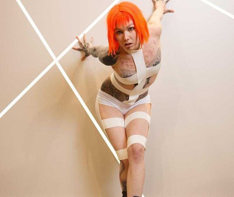 Косплей с ярко-оранжевыми волосами и татуировками на теле