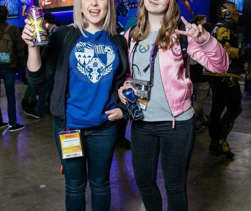 Две женщины на выставке с косплеем и напитком Samsung