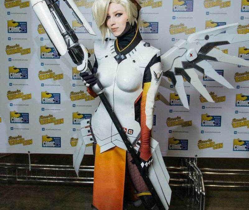 Косплей героини Overwatch с бластером и крыльями