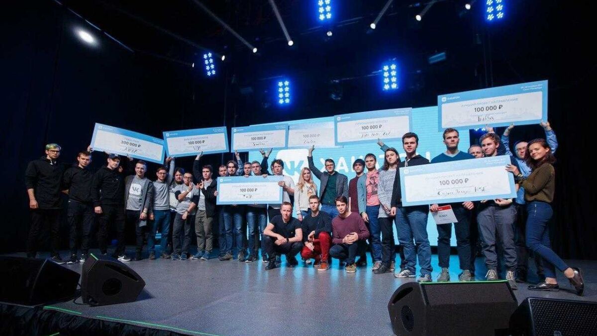 Команда участников получает крупные чеки на сцене