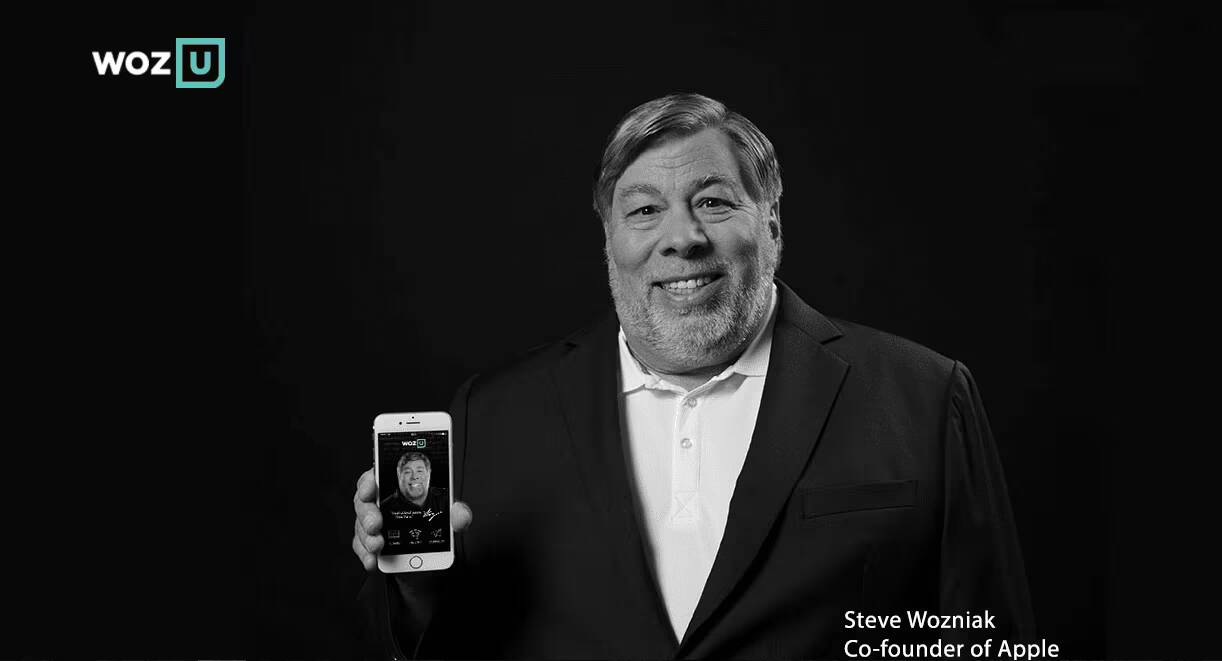 Сооснователь Apple объявил о запуске нового стартапа 1 Мужчина в деловом костюме держит iPhone с изображением человека на экране в черно-белом цвете