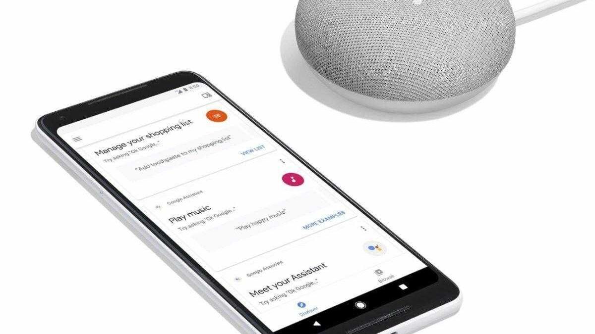 Смартфон и мини-ассистент Google Home mini на белом фоне