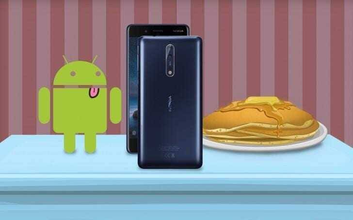 Смартфон Nokia на столе рядом с тортом и роботом Android