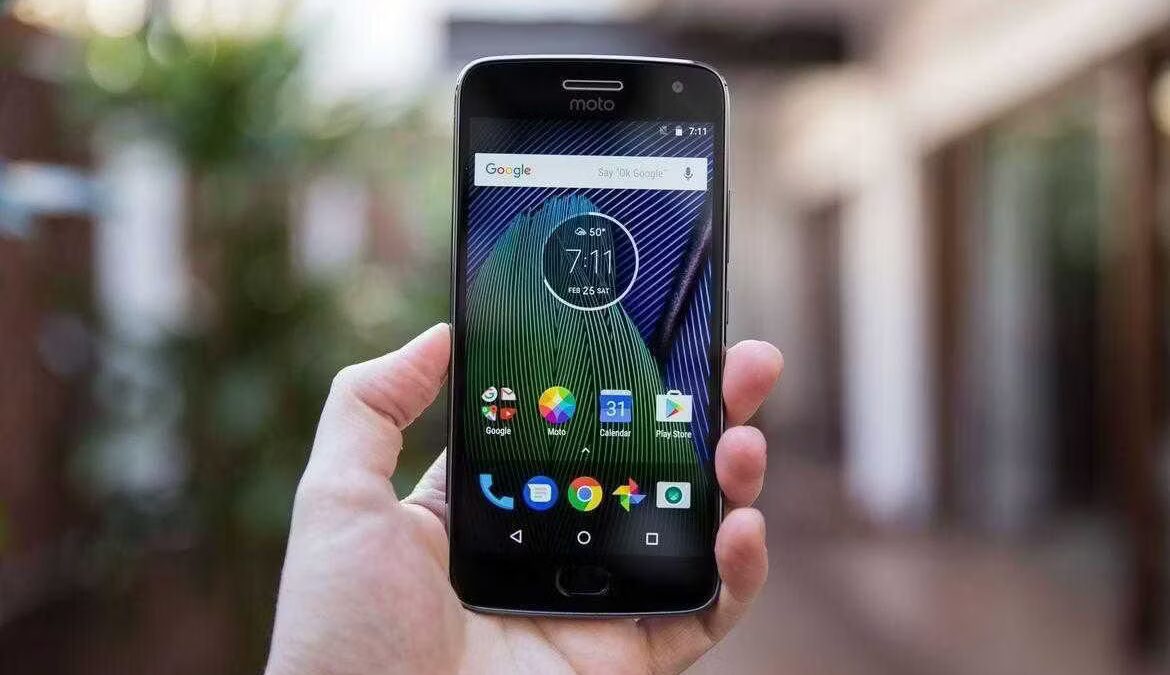 Смартфон Moto Green Pomelo в руке с интерфейсом на экране