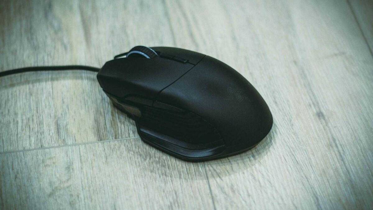 Черная игровая мышь Razer Basilisk с кабелем на деревянном полу