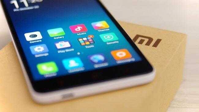Смартфон Xiaomi на белом фоне и коробка с логотипом