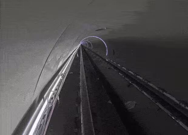 Вид внутри туннеля Hyperloop One с освещенными рельсами и линиями движения