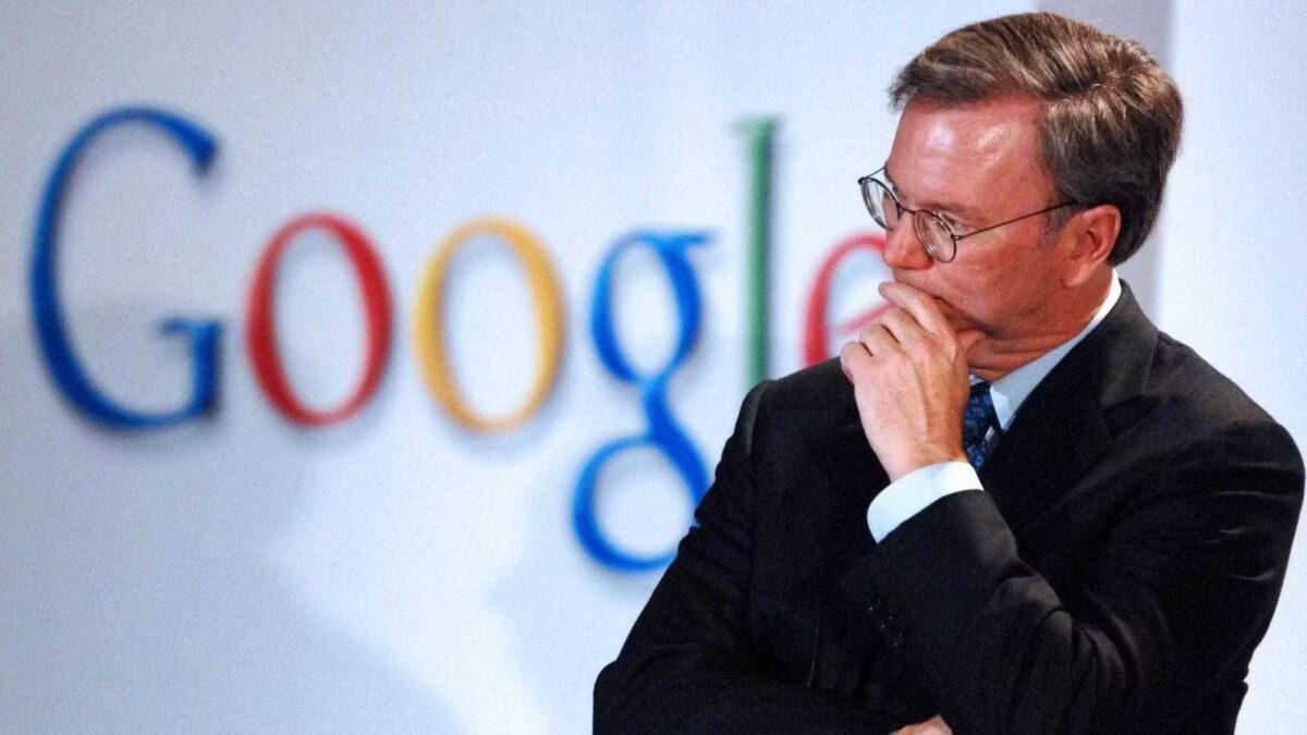 Эрик Шмидт задумчиво стоит перед логотипом Google