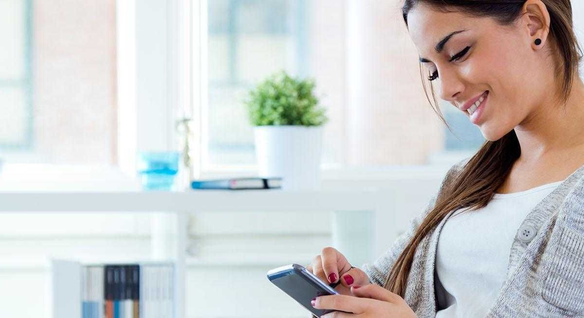 Женщина использует смартфон с большим экраном и узким корпусом