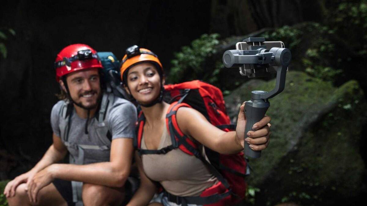 CES 2018: DJI сделал новый стабилизатор Osmo Mobile 2 5 Мужчина и женщина с рюкзаками снимают на стабилизатор DJI Osmo Mobile 2 в лесу
