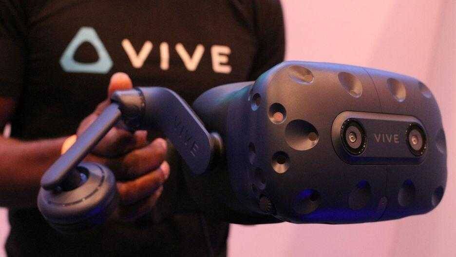 Человек держит шлем виртуальной реальности HTC Vive Pro