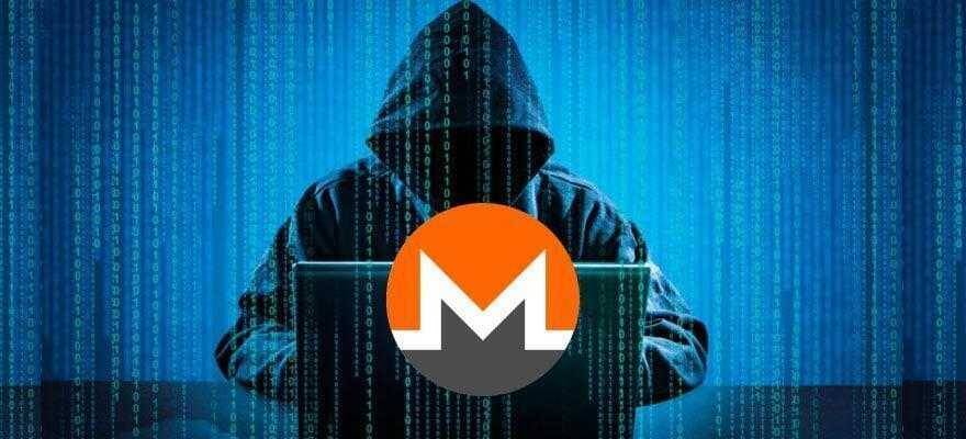 Хакер в капюшоне за ноутбуком с логотипом Monero