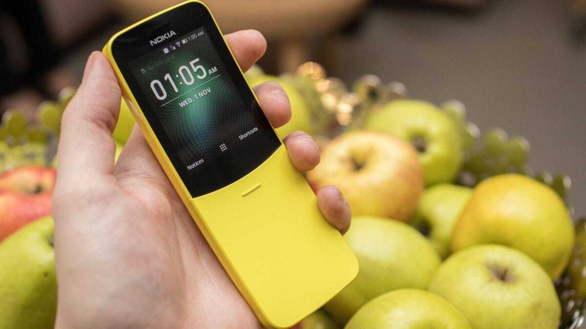 Желтый смартфон Nokia на руке перед яблоками