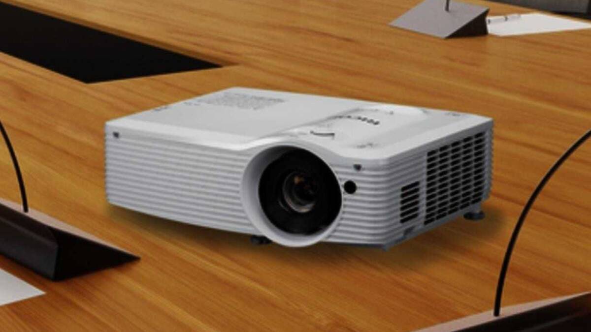Развернутый проектор Ricoh на деревянном столе под углом
