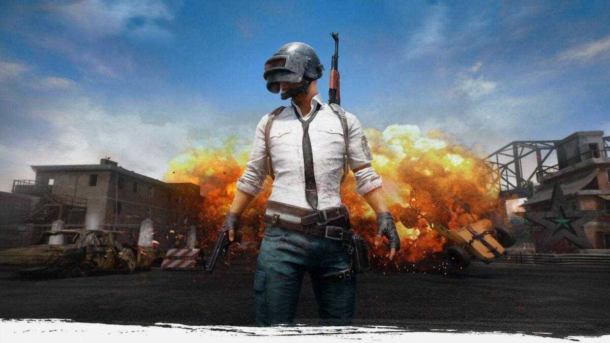 игрок в PUBG с оружием на фоне взрыва использует мышь и клавиатуру