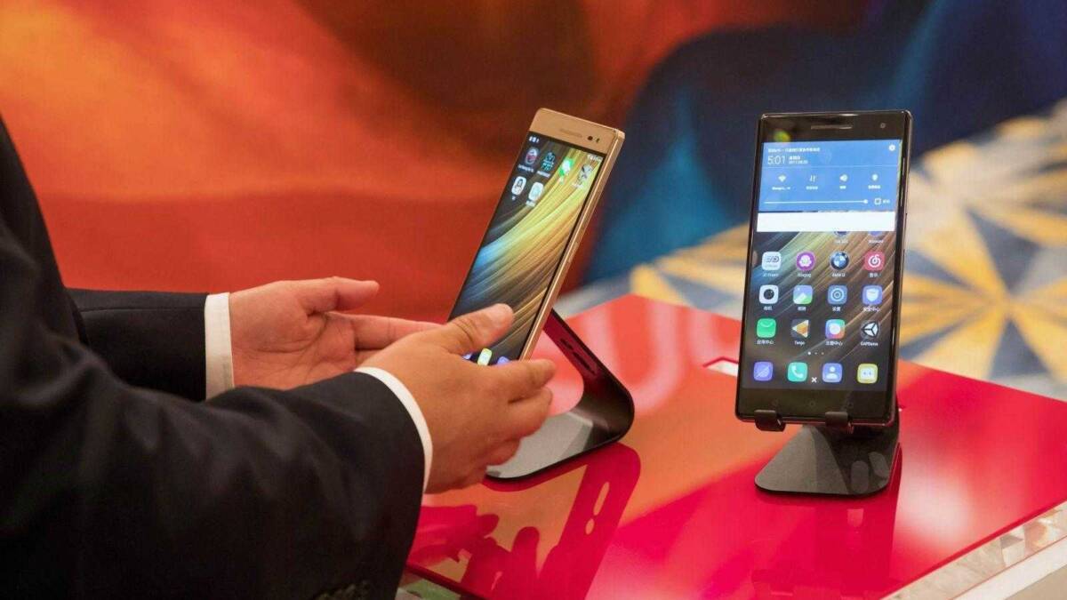 Два смартфона Lenovo на выставочном стенде с экраном