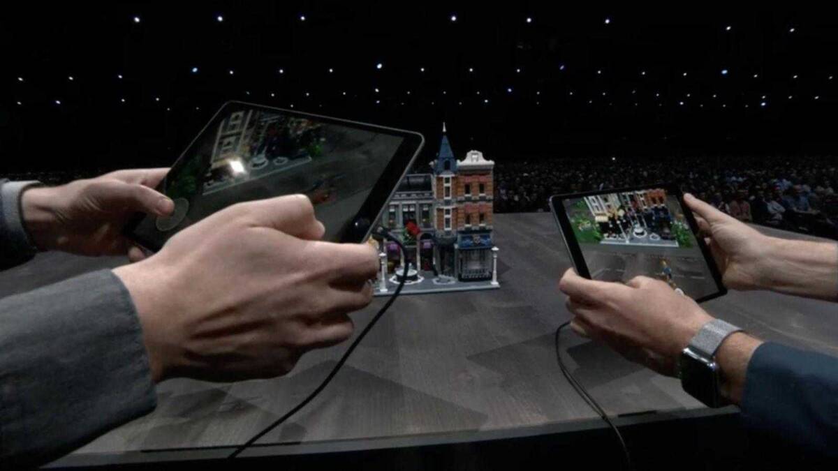 Два человека делают фотографии с помощью планшетов на конференции WWDC 2018