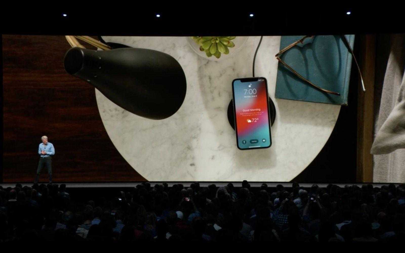 WWDC 2018. Apple представила новую быструю iOS 12. Все изменения 7 Смартфон iPhone на зарядной подставке и предметы на столе