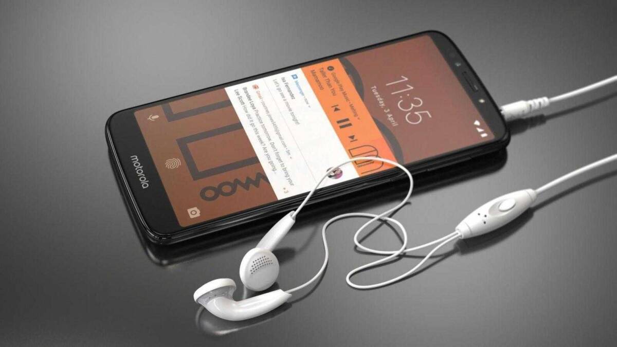 смартфон Motorola Moto G6 с наушниками подключён к зарядке