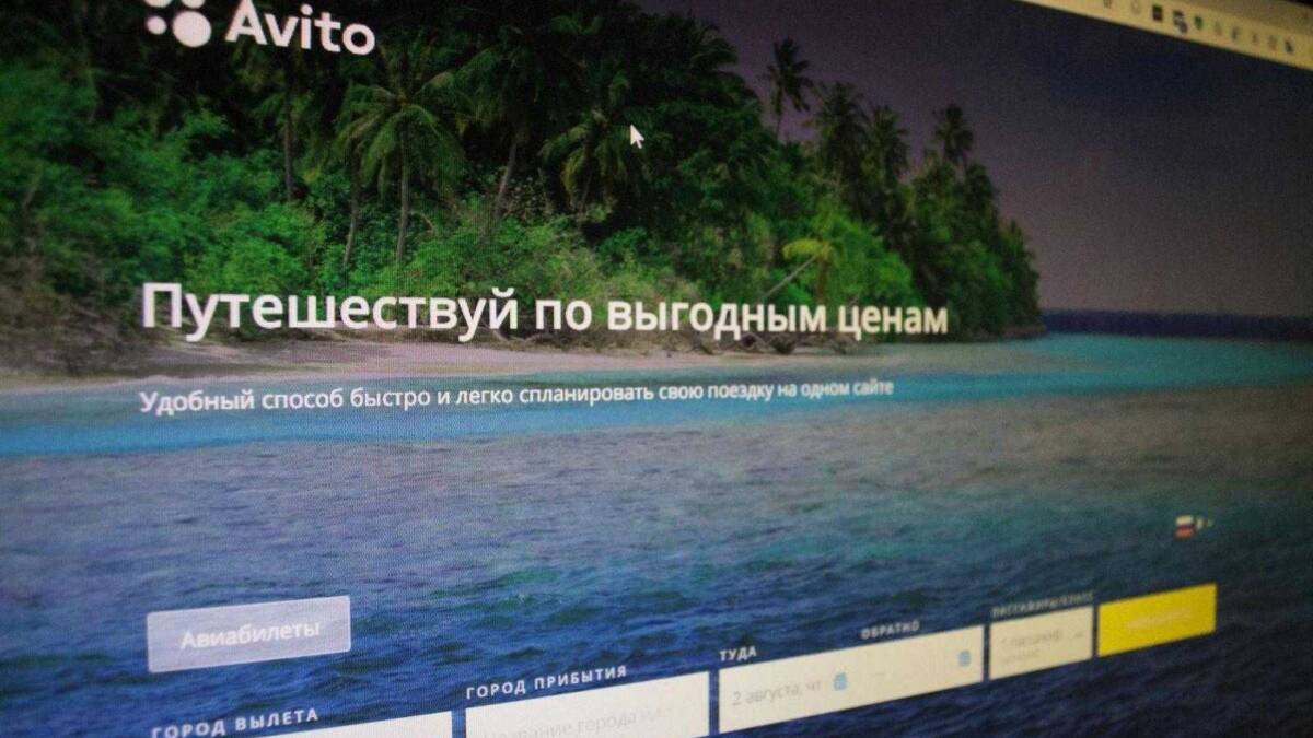 Экран сайта Авито с поиском авиабилетов на фоне пляжа и пальм