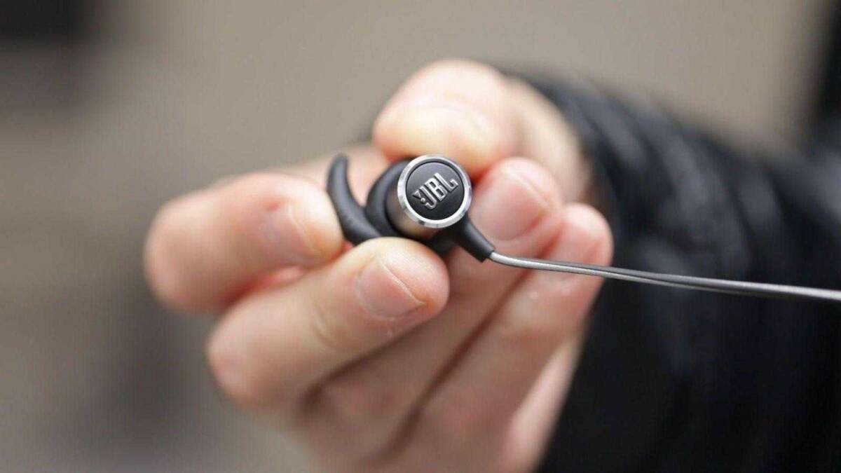 Беспроводные наушники JBL в руке крупным планом