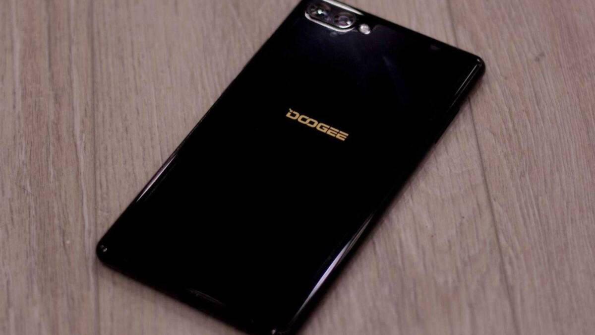 Черный смартфон Doogee на деревянном полу