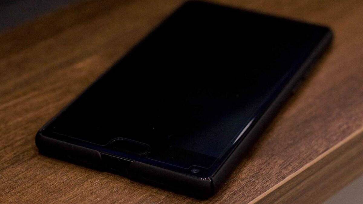 Черный смартфон на деревянной поверхности без экрана