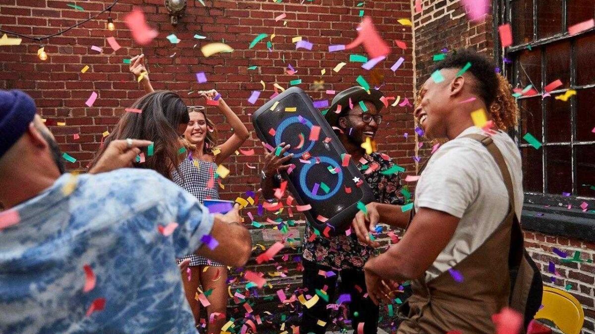 Компания людей на вечеринке с портативной колонкой JBL PartyBox 200