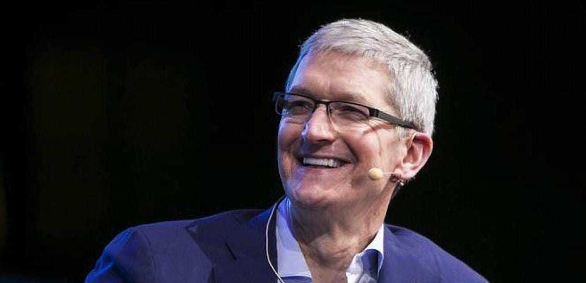 Джонатан Айв улыбается в тёмной обстановке с микрофоном