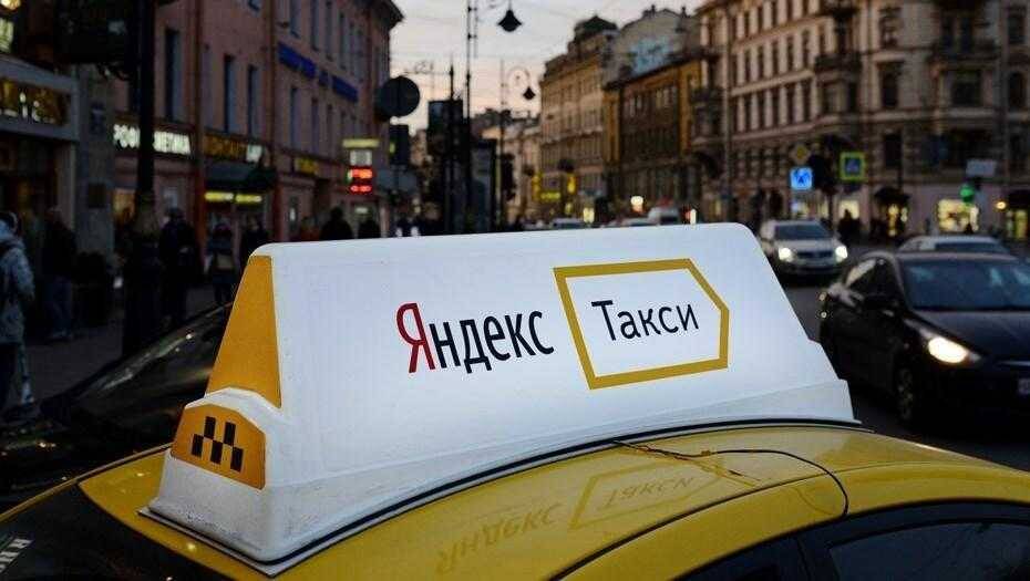 Такси с рекламой Яндекс Такси на крыше в центральной части города