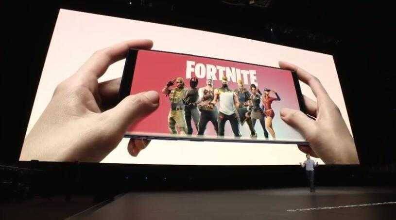 Ручное держание смартфона Samsung Galaxy Note 9 с игрой Fortnite на экране
