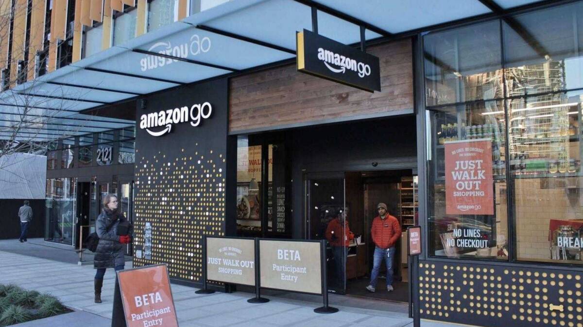 Вход в магазин Amazon go с табличками и прохожими