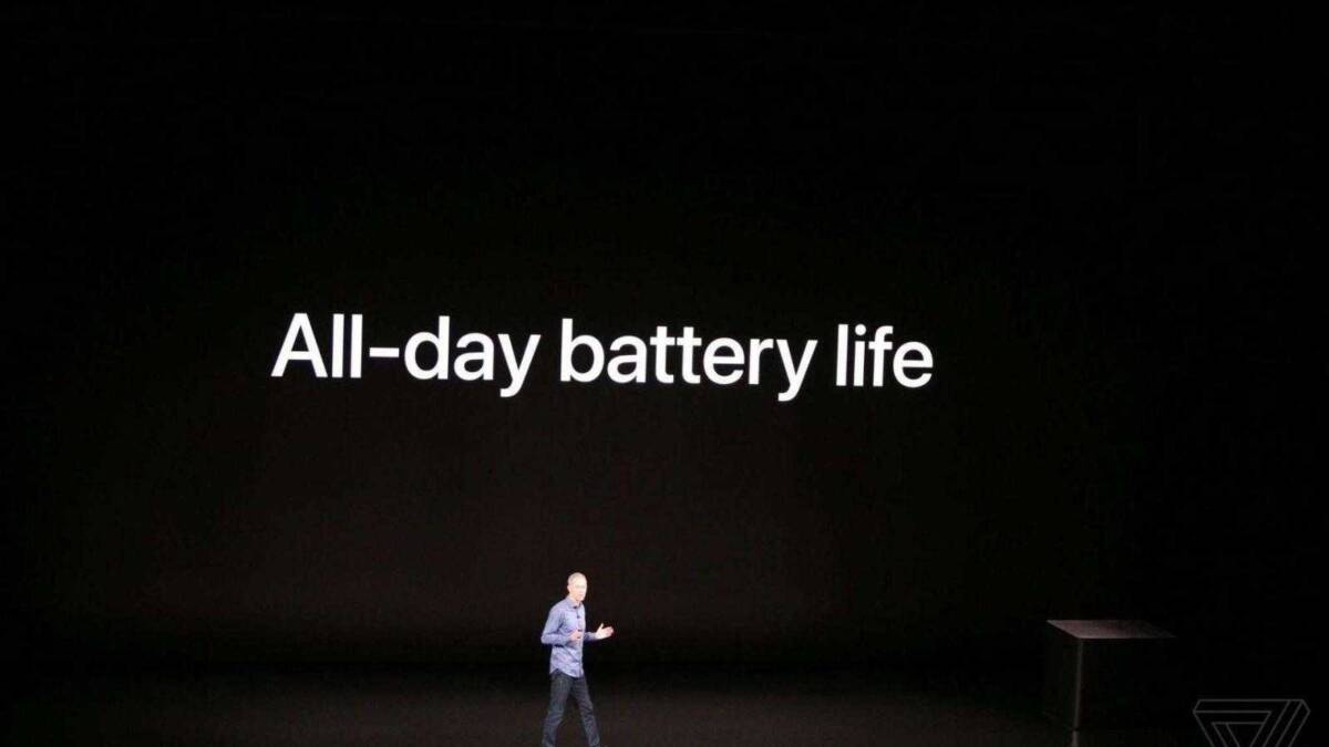 Мужчина на сцене с большим экраном указывая на текст часы Apple Watch Series 4