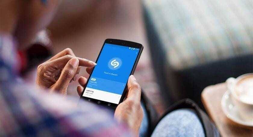Рука держит смартфон с приложением Shazam на экране