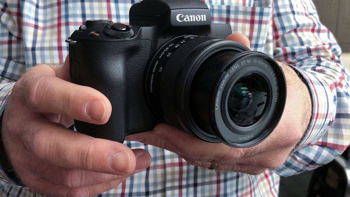 Рука держит беззеркальную камеру Canon EOS R с объективом EF-M 15-45mm