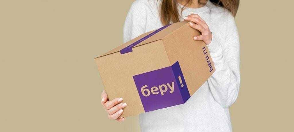 Женщина держит коробку от интернет-магазина Беру