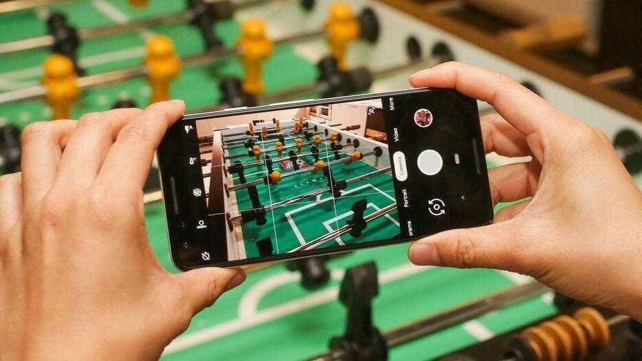 Фотография человека, снимающего кадр с телефона Pixel на футбольном столе