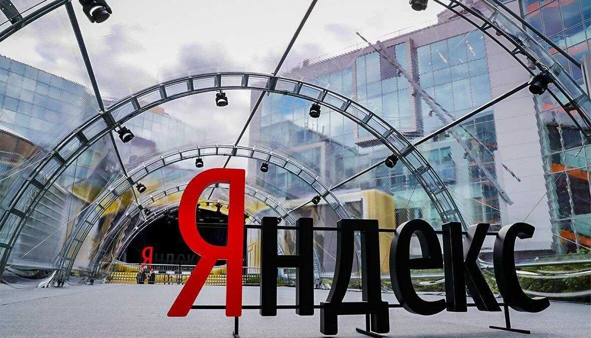 Вид с низу на логотип Яндекс перед стеклянной аркой