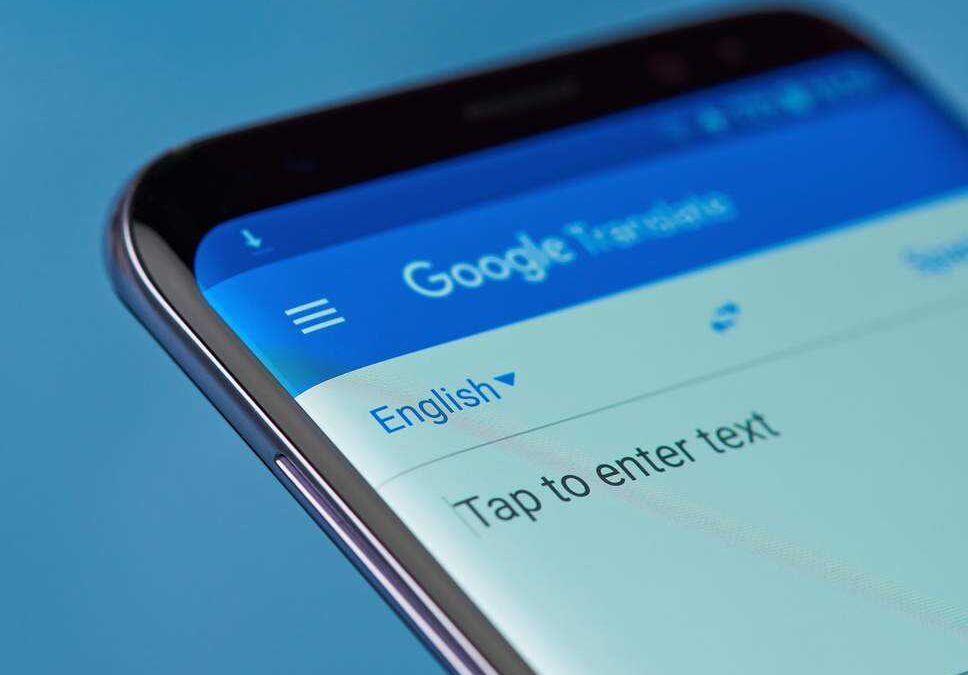 Смартфон с открытым интерфейсом Google Translate на экране
